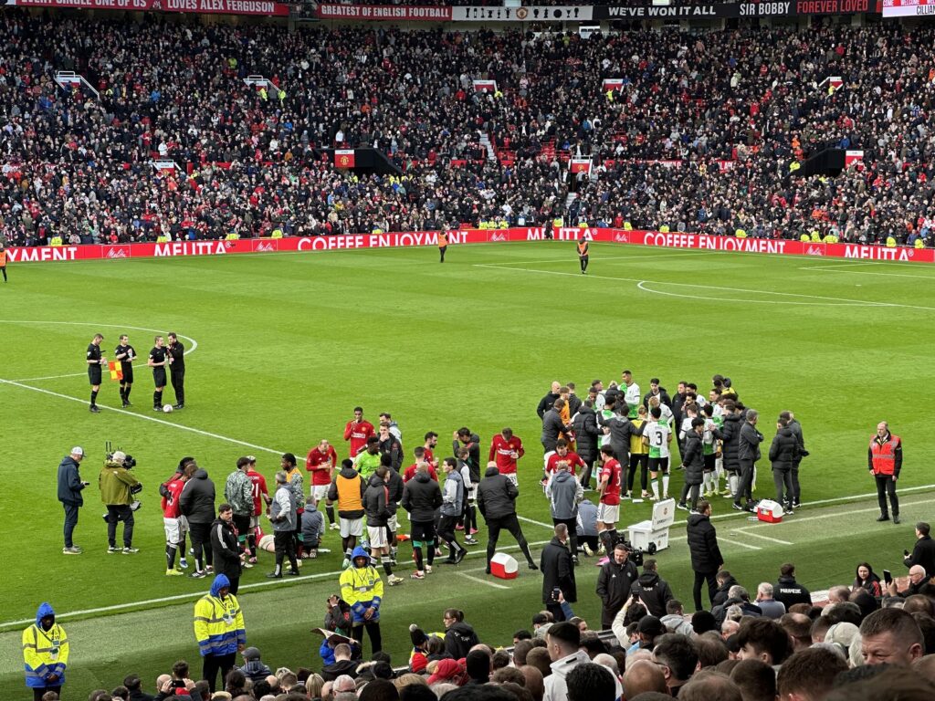 Spieler und Betreuer an der Seitenlinie während einer Unterbrechung